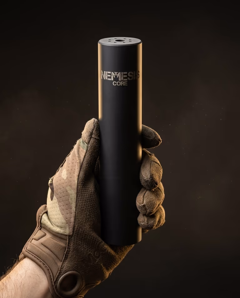 Саундмодератор NEMESIS CORE 5.56 у тактичній рукавиці - видно гравіювання NEMESIS CORE на корпусі