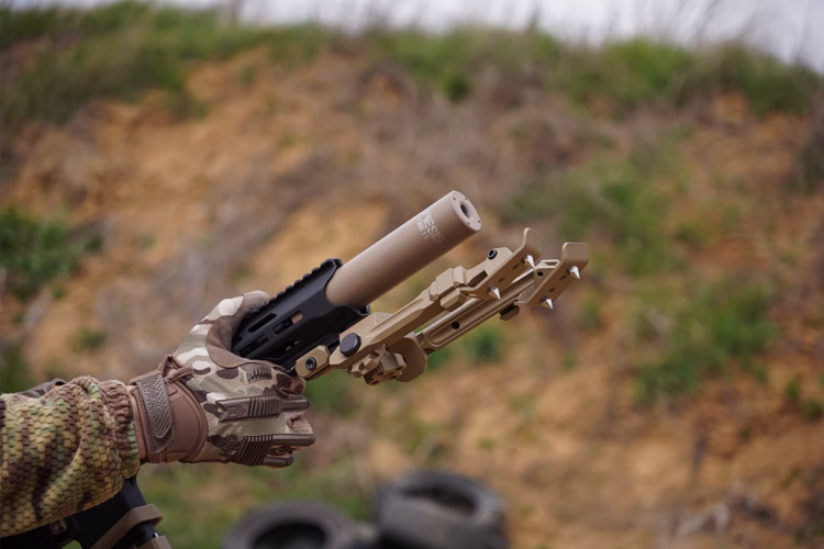 Саундмодератор NEMESIS CORE Internal 5.56 накручений на AR-15 у рукавиці, вид збоку з написом NEMESIS CORE і ДГК