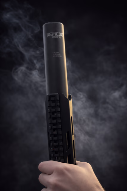 Монолітний глушник NEMESIS CORE Internal 5.56 накручений на ствол, вид знизу вгору з димом на темному фоні