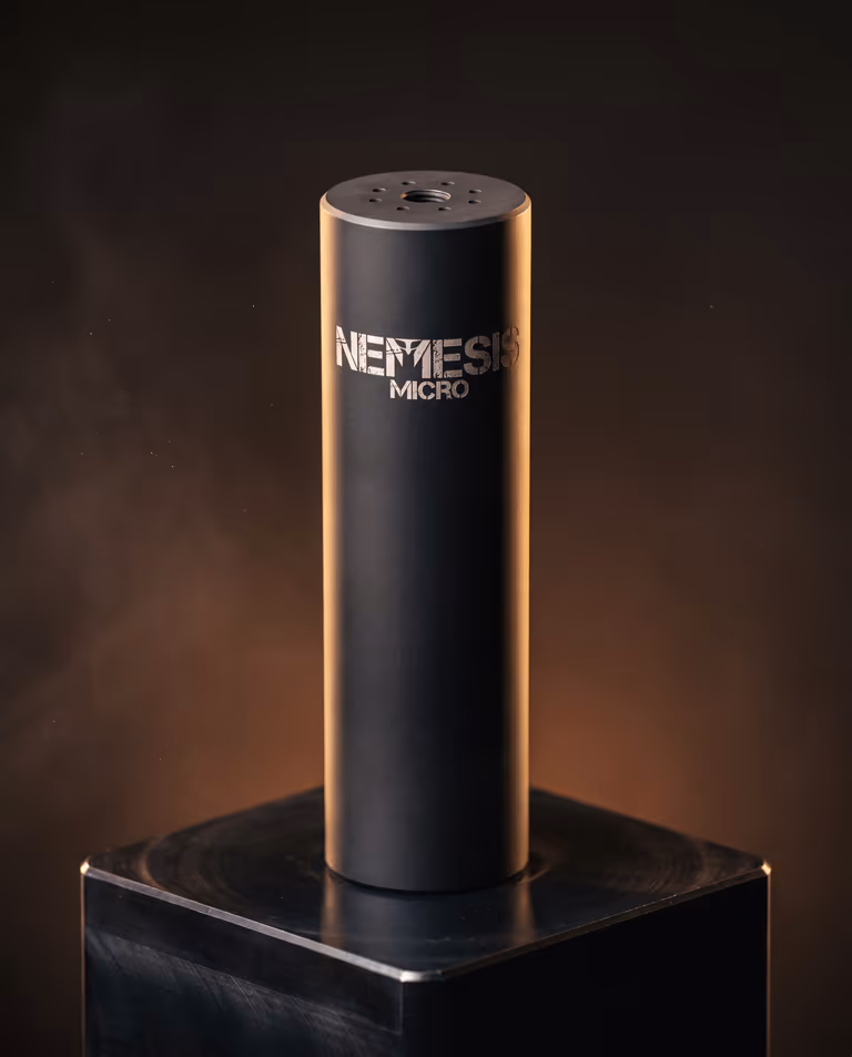Саундмодератор NEMESIS MICRO 5.56 чорний матовий вертикально на постаменті, видно торець із газовими отворами