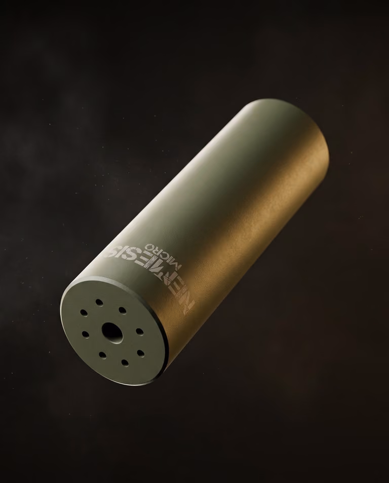 Глушник NEMESIS MICRO 5.56 у кольорі O.D. Green - діагональний ракурс у польоті, видно торець із газовими отворами та гравіювання NEMESIS MICRO