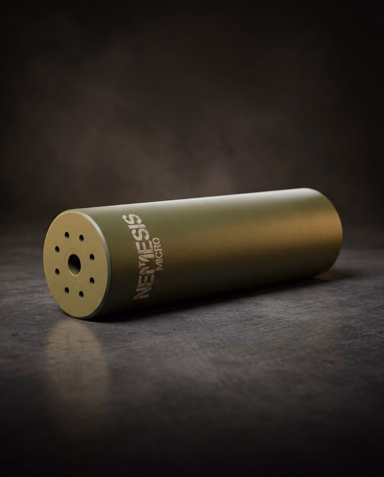 Глушник NEMESIS MICRO 5.56 O.D. Green лежить на поверхні - матовий корпус Cerakote, торець із газовими отворами