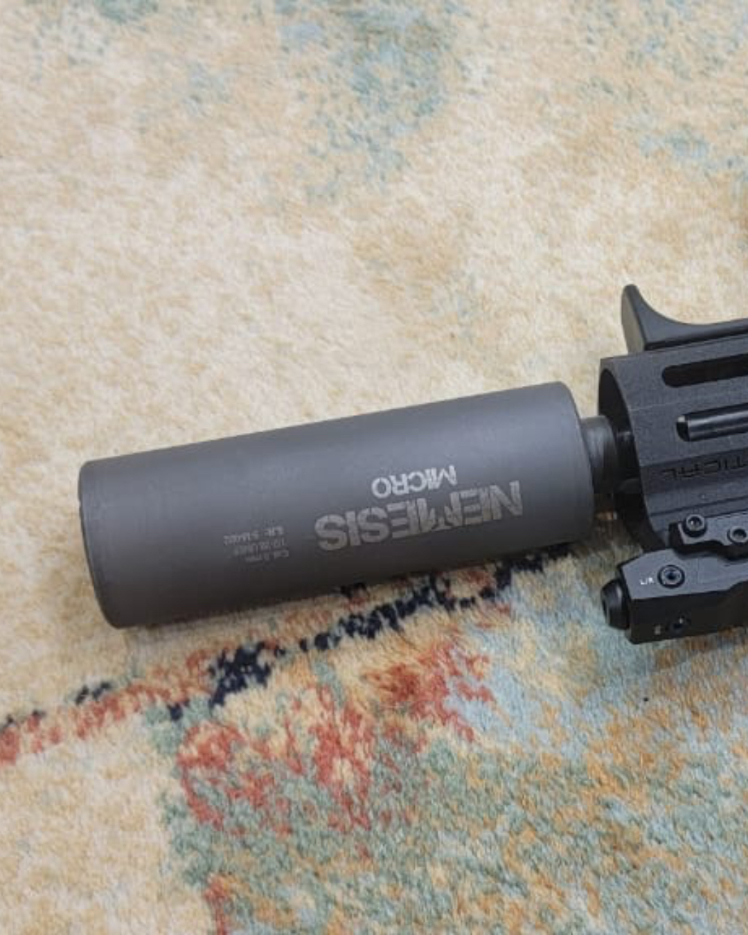 Глушник NEMESIS MICRO 9mm на поверхні поруч із коліматорним прицілом - гравіювання і серійник крупним планом